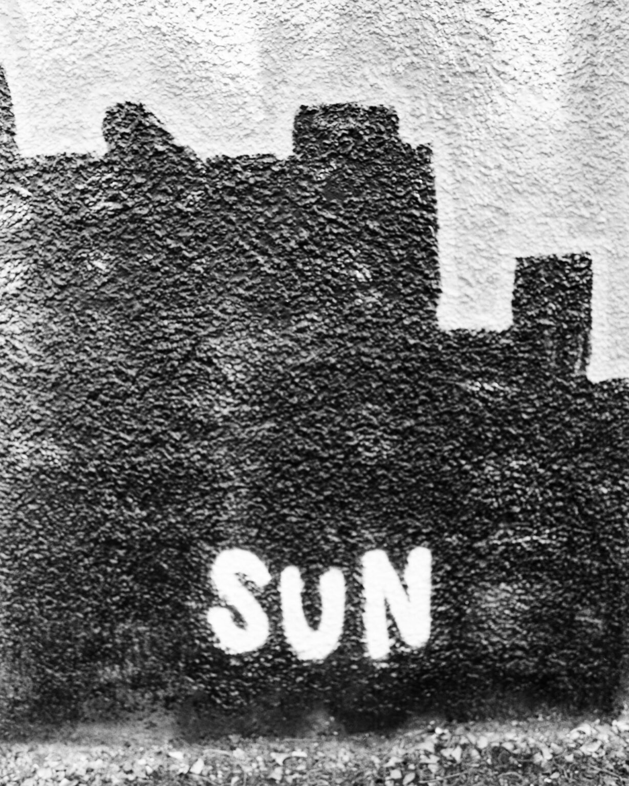 Black and white photograph of a really dark and dirty grafitti with the word sun written on it