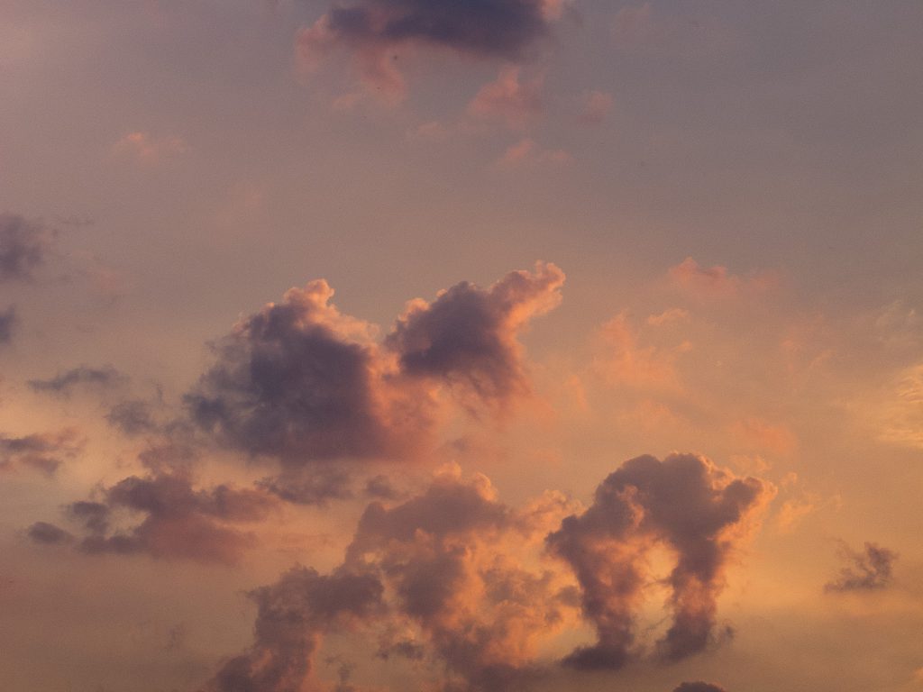 Photograph of colourful, orange-shaded clouds.