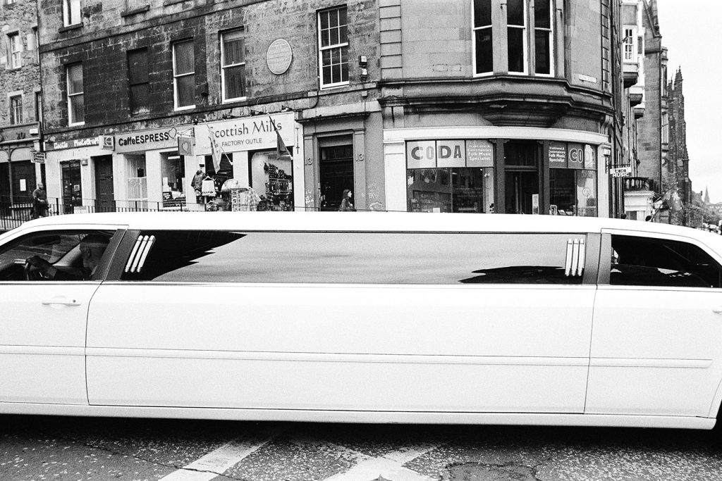 Photograph of an impossibly long, white limousine.